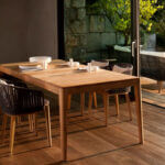 Clean teak outdoor furniture with soap water and soft brush removing dirt and stains from wooden surface