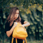 Person searching for lost house keys in bag with locksmith tools and spare keys on table