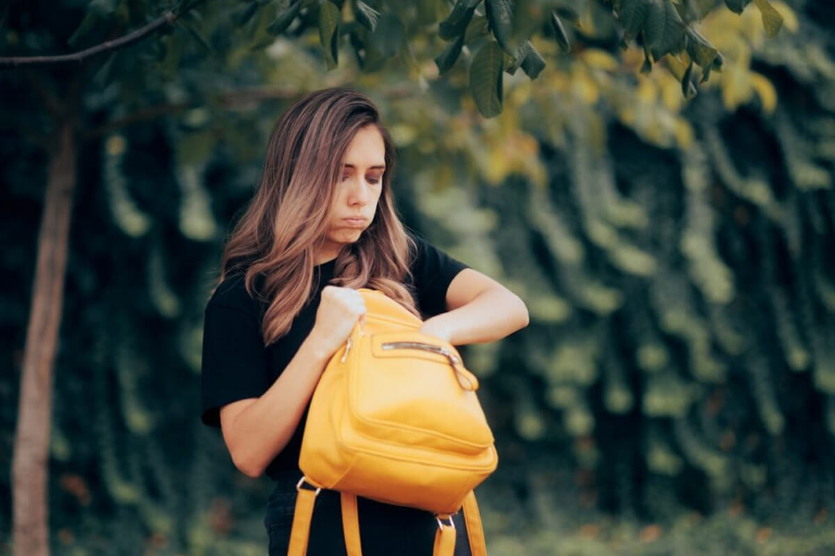 Person searching for lost house keys in bag with locksmith tools and spare keys on table