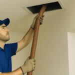 Person cleaning dirty air ducts with vacuum and brush showing how to clean air vents properly