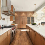 Modern kitchen renovation with white cabinets, granite countertops, and stainless steel appliances showing completed remodel