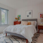 Modern bedroom rug placed under queen bed showing proper sizing and placement for contemporary bedroom decor