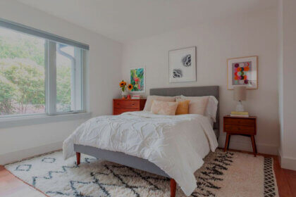 Modern bedroom rug placed under queen bed showing proper sizing and placement for contemporary bedroom decor