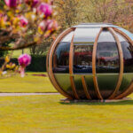 Modern garden pod outdoor structure in backyard with glass panels and seating area