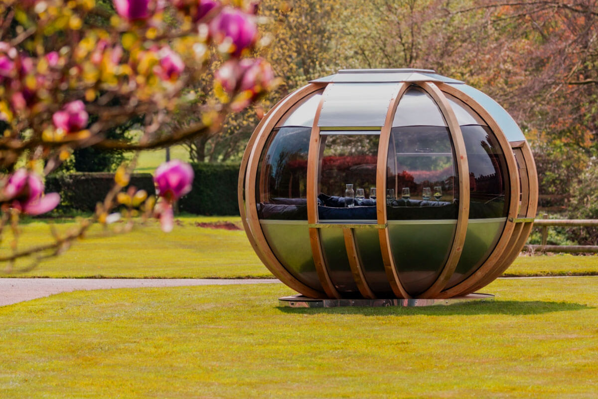 Modern garden pod outdoor structure in backyard with glass panels and seating area