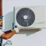 Licensed HVAC technician performing repair work on heating system in Portland Oregon home