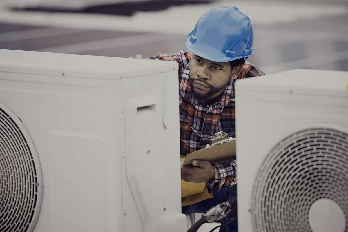 HVAC technician performing seasonal maintenance on outdoor unit with tools and checklist for energy efficiency