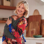 Kate Hudson kitchen with sage green cabinets, white countertops, and copper pot rack display above island