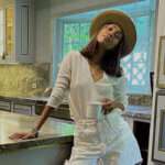 Zoe Saldana kitchen showing marble countertops, brass hardware, gray cabinets, and Officine Gullo cooking range in Beverly Hills home