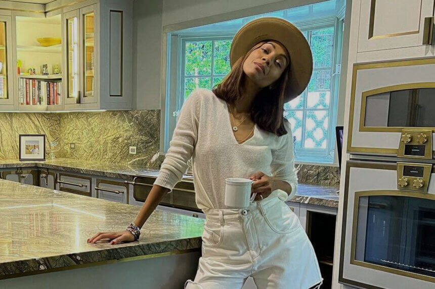 Zoe Saldana kitchen showing marble countertops, brass hardware, gray cabinets, and Officine Gullo cooking range in Beverly Hills home