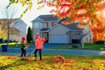 Homeowner cleaning gutters and checking roof as part of essential fall home maintenance tips before winter weather arrives