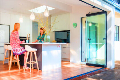 Modern glass bifold doors opening to outdoor patio creating seamless indoor-outdoor living space with natural light