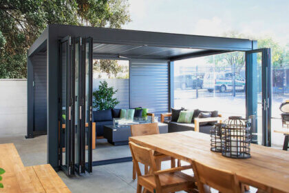 Person installing bifold door track and pivot brackets with drill and level tools for proper alignment