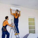 Professional technician installing new AC unit in Riverview Florida home during summer