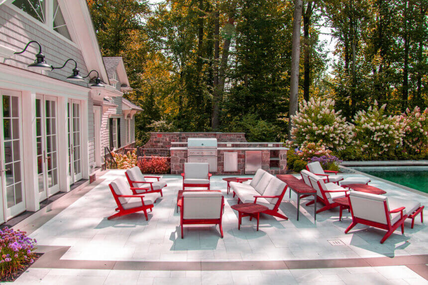 Modern outdoor pool furniture ideas featuring teak chaise lounges and weather-resistant seating around swimming pool