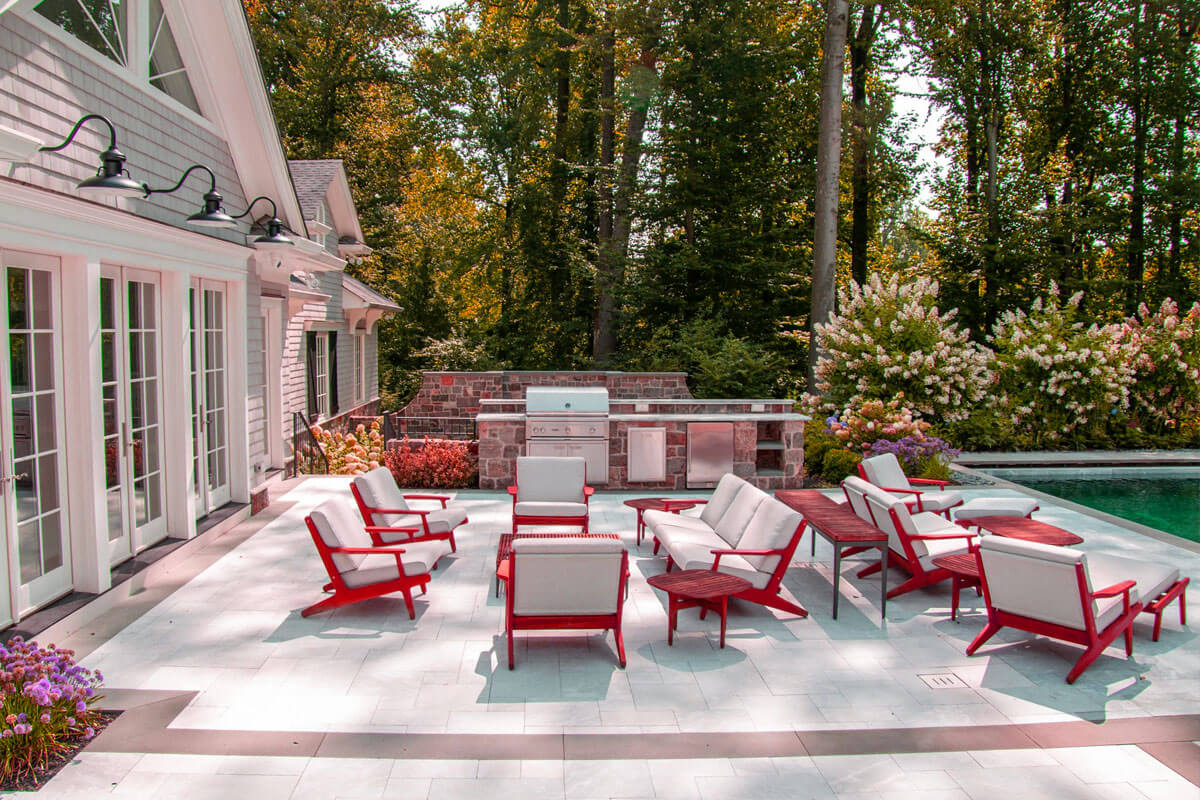 Modern outdoor pool furniture ideas featuring teak chaise lounges and weather-resistant seating around swimming pool