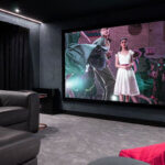 Perfect home theater setup with large screen surround sound speakers comfortable seating and controlled lighting in dark room