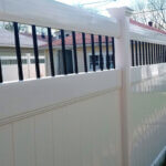 White plastic fencing panels installed in residential backyard showing durable PVC fence design and low maintenance benefits