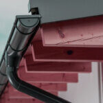 Residential roof drainage systems showing gutters and downspouts on modern home protecting foundation from water damage