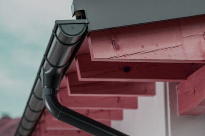 Residential roof drainage systems showing gutters and downspouts on modern home protecting foundation from water damage