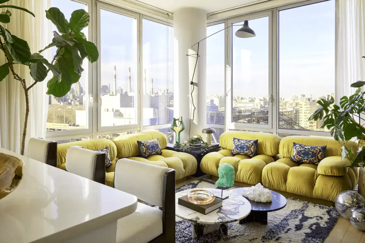 Interior design tips for small apartments showing bright living room with yellow sofa, large windows, plants, and space-saving furniture