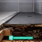 A contractor rolling liquid waterproofing membrane onto a shower pan before tile installation
