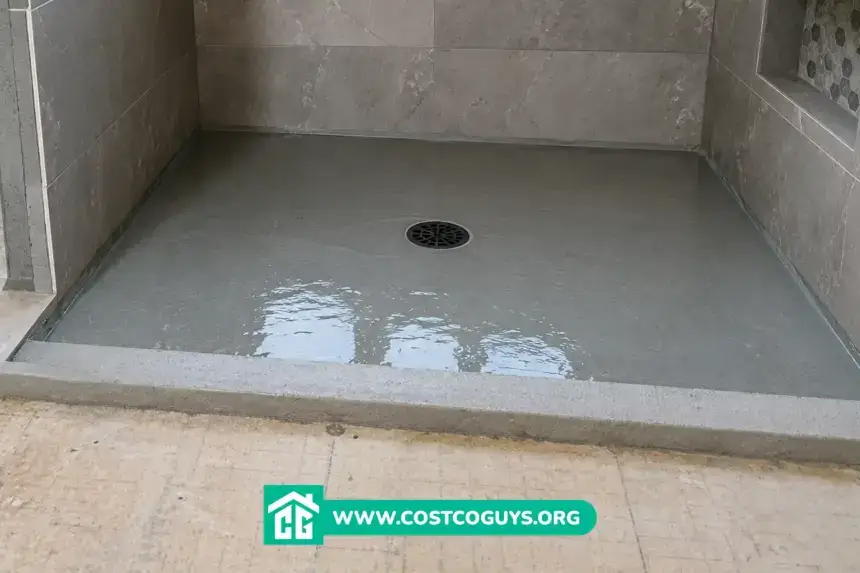 Pre Sloped Shower Base filled with water during a flood test in a tiled walk-in shower before final floor installation