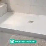 Pre-sloped shower pans in modern tiled bathroom with white rectangular base and center drain