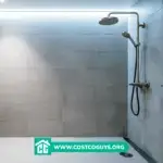 Presloped shower pan with white tiled floor and center drain in modern gray tile shower