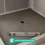 Shower Pan Pre Slope with center drain and level tool in an unfinished shower before tile installation