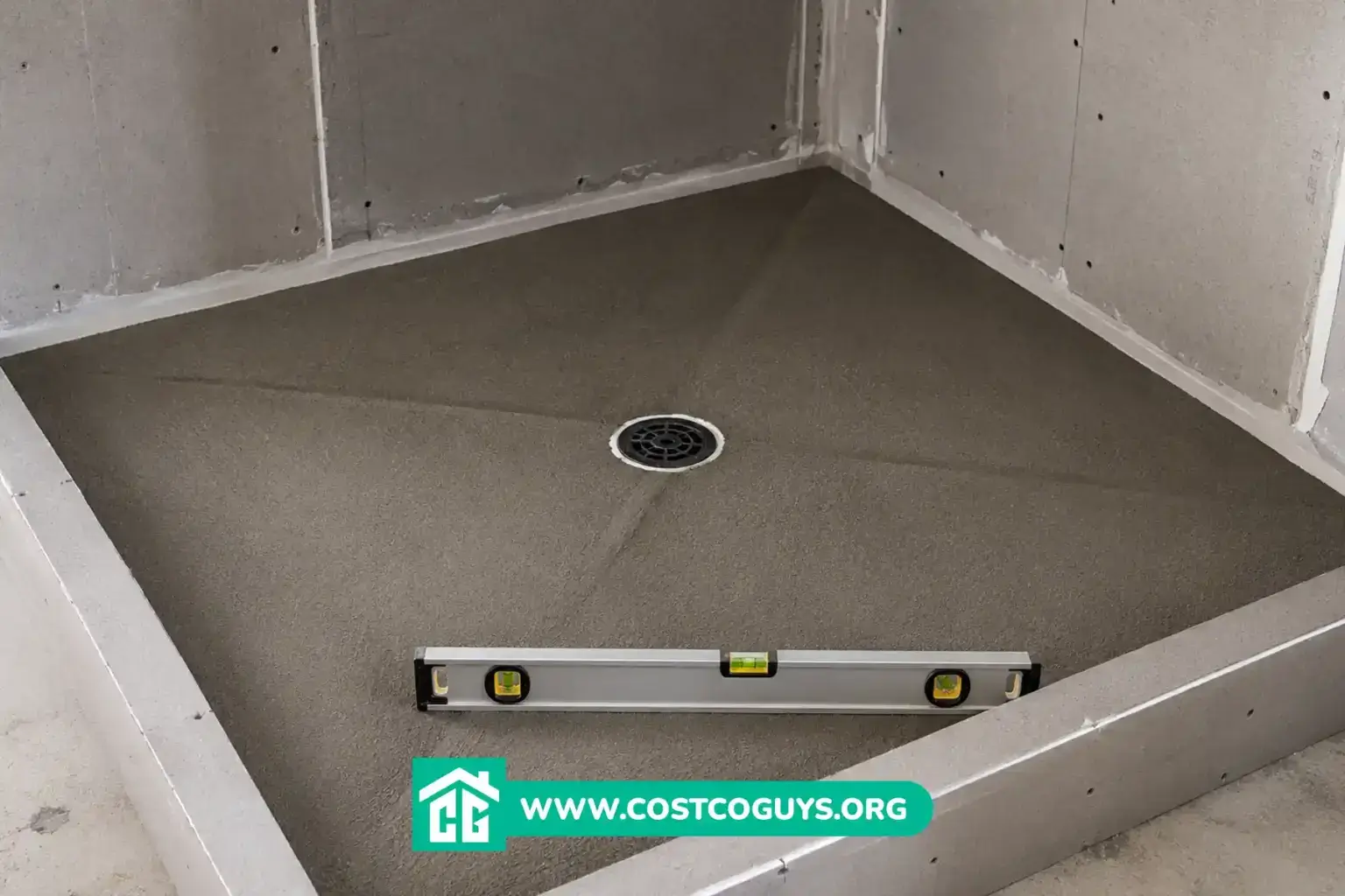 Shower Pan Pre Slope with center drain and level tool in an unfinished shower before tile installation