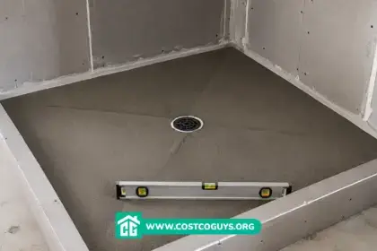 Shower Pan Pre Slope with center drain and level tool in an unfinished shower before tile installation