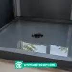 Shower pan underlayment with water-filled liner during flood test in unfinished bathroom stall