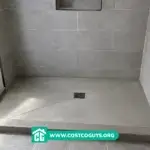 Sloped shower pan with center drain installed in a modern tiled walk-in shower under construction