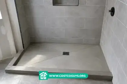 Sloped shower pan with center drain installed in a modern tiled walk-in shower under construction