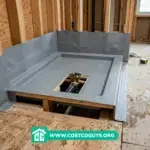 Waterproof shower pan installation featuring a gray tile-ready pre-pitched pan base on a wood subfloor.