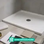 48x48 shower pan with drain, tile samples, tape measure, calculator, and renovation materials